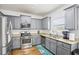 Modern kitchen with stainless steel appliances, granite countertops, and a stylish floral accent rug at 2248 Newbury Oaks Dr, Lawrenceville, GA 30044