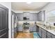 Contemporary kitchen boasting stainless steel appliances, granite countertops, and grey cabinets at 2248 Newbury Oaks Dr, Lawrenceville, GA 30044