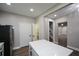 Open kitchen layout featuring bright white counters, an island, and views to a hallway and staircase at 984 Cascade Sw Rd, Atlanta, GA 30311