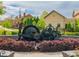 Community artwork of antique machinery surrounded by a brick wall and colorful, manicured landscaping at 1206 Red Fox Cir, Woodstock, GA 30188