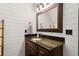Bathroom with shiplap walls, granite vanity, and framed vanity mirror at 1206 Red Fox Cir, Woodstock, GA 30188