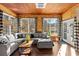 Bright living room with large windows, wood ceiling, and comfortable sectional sofa perfect for relaxation at 1206 Red Fox Cir, Woodstock, GA 30188