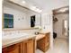 Bright bathroom vanity with wooden cabinets, granite countertop, large mirror, and a doorway leading to the walk-in closet at 213 The South Chace Ne, Sandy Springs, GA 30328