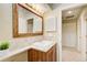 Bathroom vanity with wooden cabinets, a corner tiled countertop, framed mirror, and a doorway leading to the hallway at 213 The South Chace Ne, Sandy Springs, GA 30328