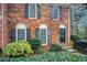 Inviting brick townhome with dark shutters and door, complemented by manicured greenery and a cozy entrance at 213 The South Chace Ne, Sandy Springs, GA 30328