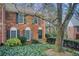 Charming brick townhome with a well-manicured front yard featuring lush greenery and mature trees at 213 The South Chace Ne, Sandy Springs, GA 30328