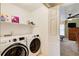 Convenient laundry room with modern washer and dryer adjacent to a cozy, inviting bedroom at 213 The South Chace Ne, Sandy Springs, GA 30328