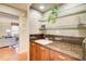 Home wet bar with sink, granite countertop, and wood cabinetry, adjacent to the spacious living room at 213 The South Chace Ne, Sandy Springs, GA 30328