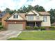 Charming two-story home with a brick and siding exterior, well-manicured lawn, and attached two-car garage at 3070 Ridge Oak Dr, Suwanee, GA 30024