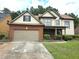 Charming two-story home with a brick and siding exterior, well-manicured lawn, and attached two-car garage at 3070 Ridge Oak Dr, Suwanee, GA 30024