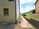 View of the side yard featuring a retaining wall, landscaped garden, and greenery at 3070 Ridge Oak Dr, Suwanee, GA 30024
