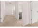 Hallway featuring white trim, multiple doorways, and neutral-toned carpet at 169 Aster Avenue, Locust Grove, GA 30248