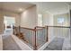 Bright hallway with wood and iron railing, and an open view to a bedroom with carpeted floors at 104 Camilla Dr, Carrollton, GA 30116