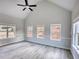 Spacious bedroom boasting vaulted ceilings, light gray walls, wood-look floors, and three bright windows at 690 Park Place Way, Social Circle, GA 30025