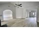 Open concept living room with wood-look floors, arches, and light neutral walls at 690 Park Place Way, Social Circle, GA 30025