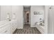 Bright bathroom with a soaking tub, dual vanity, wood-look floors, and access to a walk-in closet at 224 Shoals Bridge Rd, Acworth, GA 30102
