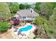 Aerial view of home with in-ground pool nestled in an expansive wooded lot at 8155 Legends View Ct, Cumming, GA 30028