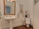 This stylish bathroom features a pedestal sink, wood floors, and charming decor at 8155 Legends View Ct, Cumming, GA 30028
