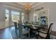 Bright dining room with large windows, chandelier, and table set, creating a warm and inviting space at 8155 Legends View Ct, Cumming, GA 30028