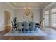 Elegant dining room with a chandelier, large windows, and a table set for a formal meal at 8155 Legends View Ct, Cumming, GA 30028