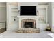 Living area with stone fireplace, built-in bookshelves, and a mounted television at 8155 Legends View Ct, Cumming, GA 30028