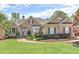 Charming brick home featuring a well-manicured lawn and landscaped front yard with a welcoming entrance at 8155 Legends View Ct, Cumming, GA 30028