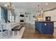Open kitchen and dining area with wood floors, blue island, and brick fireplace at 8155 Legends View Ct, Cumming, GA 30028