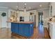 This bright kitchen features a blue island, stainless appliances, and hardwood floors at 8155 Legends View Ct, Cumming, GA 30028