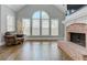 Bright living room with a brick fireplace, hardwood floors, and large windows at 8155 Legends View Ct, Cumming, GA 30028