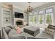 Cozy living room featuring a fireplace, built-in bookshelves, and large windows with serene outdoor views at 8155 Legends View Ct, Cumming, GA 30028