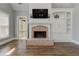 This spacious living room has a brick fireplace, hardwood floors, and a door to the outside at 8155 Legends View Ct, Cumming, GA 30028