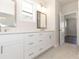 Bathroom featuring a double sink vanity with white cabinets, stylish mirrors, and modern fixtures at 161 Basil St, Cumming, GA 30040