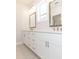 Bathroom featuring a double sink vanity with white cabinets, stylish mirrors, and modern fixtures at 161 Basil St, Cumming, GA 30040