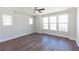 Bright bedroom with dark hardwood floors, crown molding, ceiling fan and multiple windows for ample natural light at 161 Basil St, Cumming, GA 30040