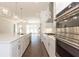Spacious kitchen with quartz island, stainless appliances, and hardwood floors connecting to a bright living area at 161 Basil St, Cumming, GA 30040