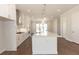 Open kitchen with white cabinets, stainless steel appliances, a large island, and hardwood floors at 161 Basil St, Cumming, GA 30040