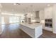 Bright, open-concept kitchen featuring a large island, stainless steel appliances, and hardwood flooring at 161 Basil St, Cumming, GA 30040
