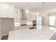 Bright kitchen features an island with pendant lighting, modern appliances, and sleek white cabinetry at 161 Basil St, Cumming, GA 30040