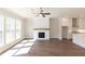 Bright, open living room featuring a fireplace, hardwood floors, and a view of the kitchen area at 161 Basil St, Cumming, GA 30040