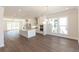 Open concept living space with hardwood floors connecting to a kitchen with a quartz island at 161 Basil St, Cumming, GA 30040