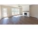 Sun-filled living room features a modern fireplace, hardwood floors and large windows with wooded view at 161 Basil St, Cumming, GA 30040