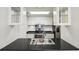Kitchen with black counters, stainless steel appliances, and glass faced cabinets at 3481 Lakeside Ne Dr # 807, Atlanta, GA 30326