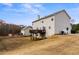 Rear exterior of home featuring a deck, spacious yard, and view of the garage and a neighboring house at 4695 Ferncrest Pl, Douglasville, GA 30135