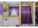 Bright bathroom featuring a soaking tub with purple accents, a window, and a shower with a purple curtain at 4695 Ferncrest Pl, Douglasville, GA 30135