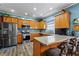 Fully equipped kitchen with breakfast bar seating, stainless appliances, and wood cabinetry at 4695 Ferncrest Pl, Douglasville, GA 30135