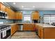 U-shaped kitchen featuring wood cabinets, stainless steel appliances, and modern flooring at 4695 Ferncrest Pl, Douglasville, GA 30135