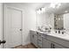 Elegant bathroom with double sinks, quartz countertops, modern fixtures and a large, bright mirror at 733 Stickley Oak Way, Woodstock, GA 30189