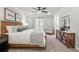 Serene main bedroom featuring a ceiling fan, neutral decor, and a cozy sitting area near the bright window at 733 Stickley Oak Way, Woodstock, GA 30189