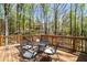 Enjoy outdoor living on this wooden back deck with black metal table and chairs surrounded by nature at 3560 Chattahoochee Rd, Cumming, GA 30041