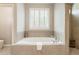 Relaxing bathroom with soaking tub, separate tiled shower, and natural light from shuttered window at 3560 Chattahoochee Rd, Cumming, GA 30041
